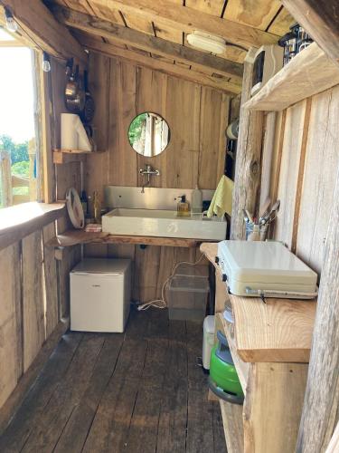 La salle de bains est pourvue d'un lavabo et d'une baignoire. dans l'établissement Nuit *é* Toilée à la Ferme du Petit Puyaume, à Montravers