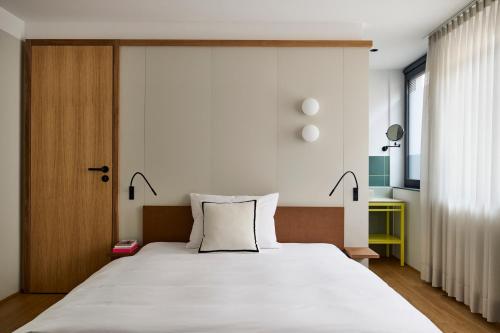 a bedroom with a large white bed with two lamps at LUIS Boutique Hotel in Aalen