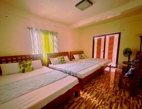 a bedroom with two beds and a window at Julz Ridge Exclusive Place in Bayombong in Bayombong