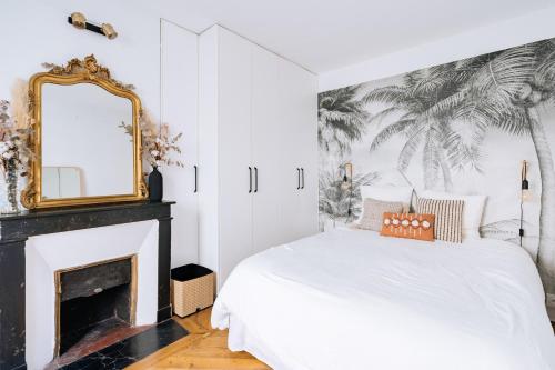 - une chambre avec un lit avec un miroir et une cheminée dans l'établissement Alluring 1 bedroom Apartment 5 min to the Eiffel Tower!, à Paris