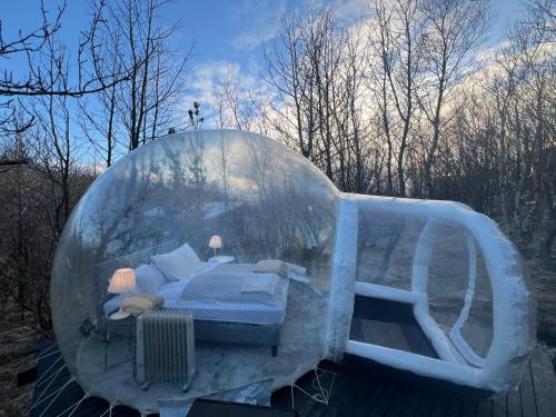 a bed in a igloo with a bed in it at Eyja Mork - Aurora Igloo with shared Hot Tub, BBQ and kitchen - B2 in Stora Mork