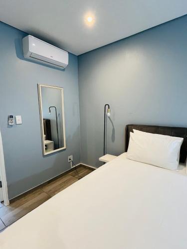 Un dormitorio con una cama grande y un espejo. en Heavenly Towers, en Mbazwana