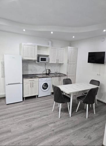 a kitchen with white appliances and a table and chairs at Apartament Suită 4 in Chişinău