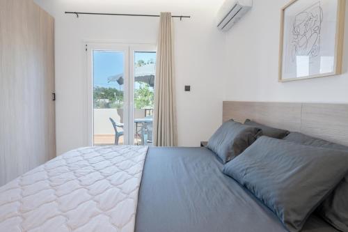 a bedroom with a bed with a view of a patio at Stone and Sea Kos Oasis in Kos Town