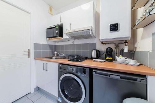 une petite cuisine avec une machine à laver et un évier dans l'établissement 205 - studio cosy vue sur le musee - Paris 5 - FLAT-GUEST, à Paris