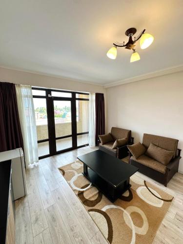a living room with a couch and a table at Отель Асман in Bosteri