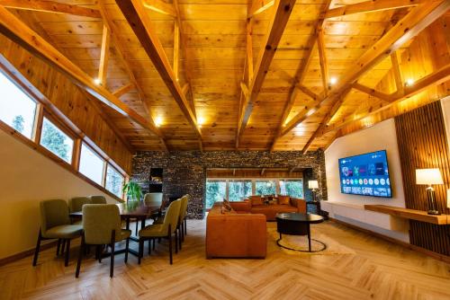 a living room with wooden ceilings and a tv at EAFR Hotel in Nathia Gali