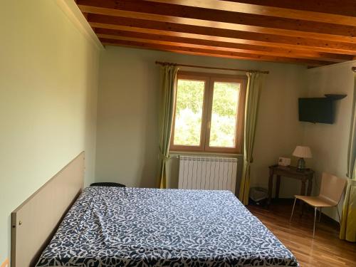a bedroom with a bed with a blue comforter and a window at ABAKAINON COUNTRY B & B in Tripi