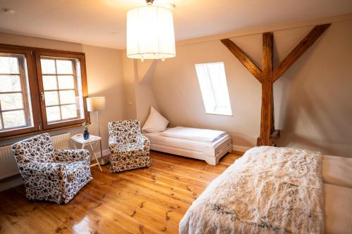 a bedroom with a bed and a chair and a table at Gut Alt Necheln in Brüel