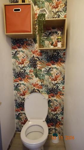 La salle de bains est pourvue de toilettes et de papier peint à fleurs. dans l'établissement La Comtesse, à Saint-Gervais-les-Bains