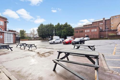 a group of picnic tables in a parking lot at Stylish Dudley Studio with Kitchen and Parking in Dudley