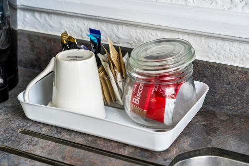 a tray with a jar and utensils on a counter at Stylish Dudley Studio with Kitchen and Parking in Dudley