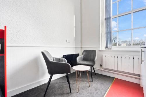two chairs and a table in a room with a window at Stylish Dudley Studio with Kitchen and Parking in Dudley