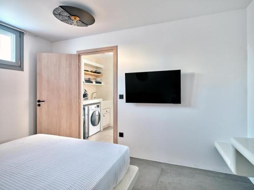a bedroom with a bed and a tv on the wall at Ocean View Paros in Parikia