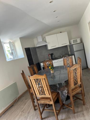 a kitchen with a dining room table and chairs at Gîte meublé in Pont-Trambouze