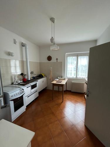 a kitchen with white appliances and a wooden floor at Residenza le due Rose in Ronzone