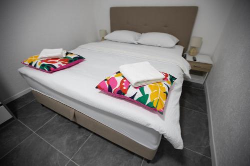 a bed with two towels on top of it at Apartmani Trio in Trebinje
