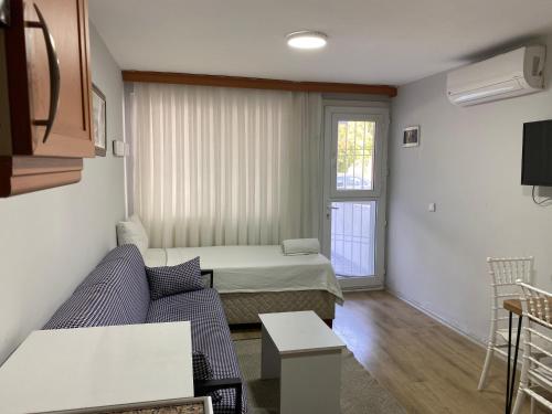 a living room with a couch and a bed at İZAN VİLLA BAKIŞ APARTMENTS in Bodrum City