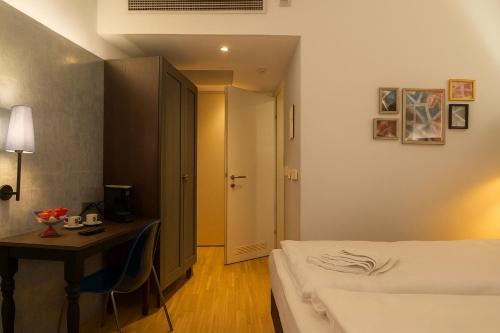 a hotel room with a bed and a table and a desk at Hotel Memories Budapest in Budapest