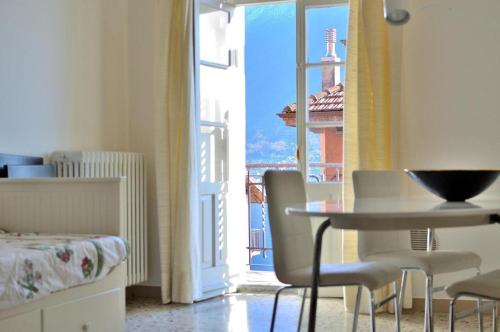 a room with a table and chairs and a window at The Family Houses - Apartments with Balcony and Lake View in Colonno