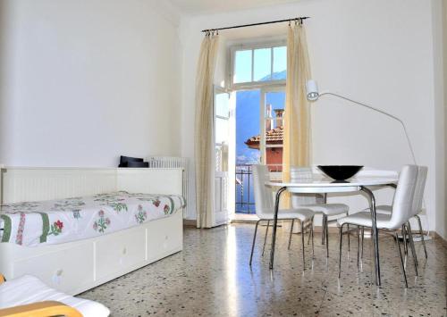 a bedroom with a bed and a table and chairs at The Family Houses - Apartments with Balcony and Lake View in Colonno