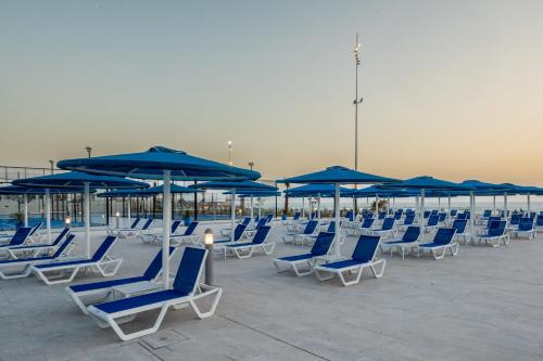 a group of blue chairs and umbrellas on a patio at Pickalbatros Palais Des Roses - Agadir - All Inclusive in Agadir
