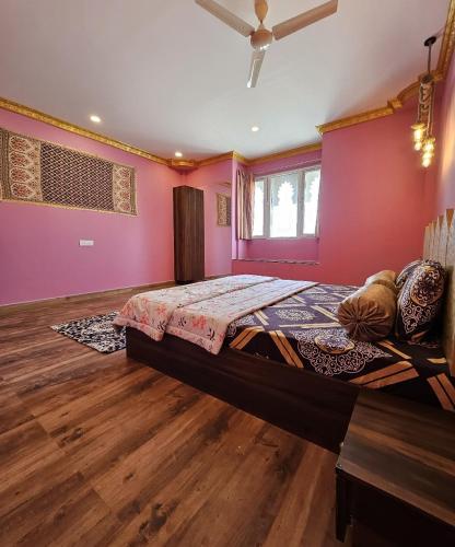 a bedroom with pink walls and a large bed at Rajputana Palace with Private Pool by Homeyhuts in Hyderabad