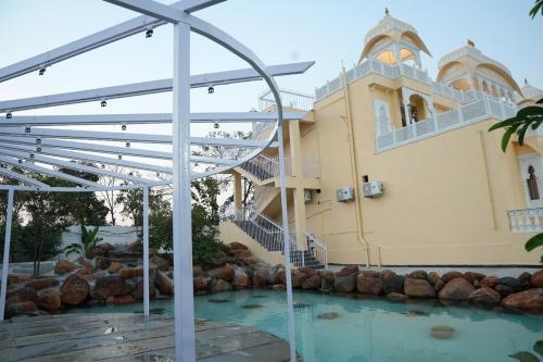 a building with a swimming pool in front of a building at Rajputana Palace with Private Pool by Homeyhuts in Hyderabad
