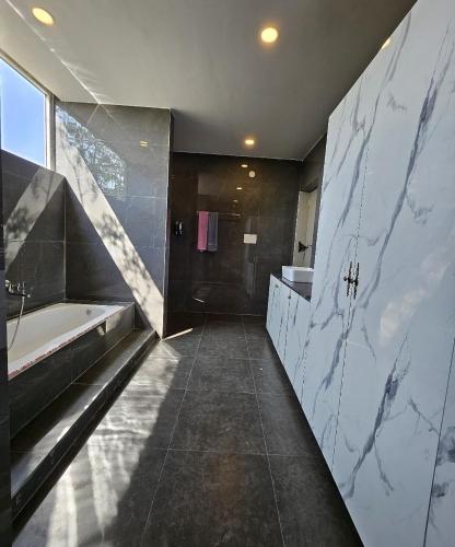 a bathroom with a tub and a sink and a bath tub at Rajputana Palace with Private Pool by Homeyhuts in Hyderabad