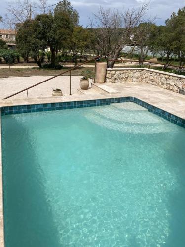une grande piscine avec de l'eau bleue dans l'établissement La Maison Bonne Aventure, à Saint-Mitre-les-Remparts