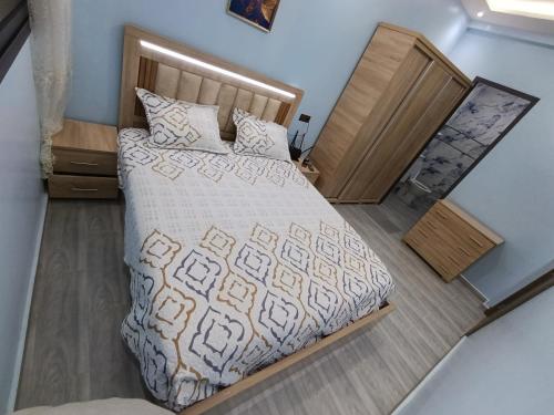 a bedroom with a large bed with a wooden headboard at La maison bleu in Oulad Akkou