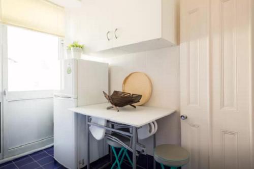 a small kitchen with a table and a refrigerator at Glória Apartment in Lisbon