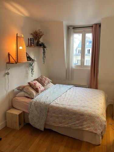 une chambre avec un lit et une fenêtre dans l'établissement Joli appartement dans le centre de Paris, à Paris