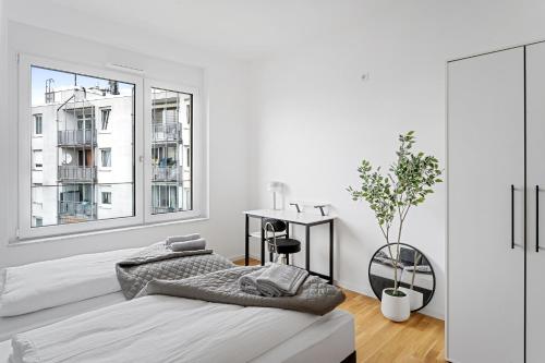 a white bedroom with a bed and a desk at EXQUIS Design 2BR Apartment HANSEN I Balcony I Mercedes & US Army I Parking I Stuttgart in Böblingen