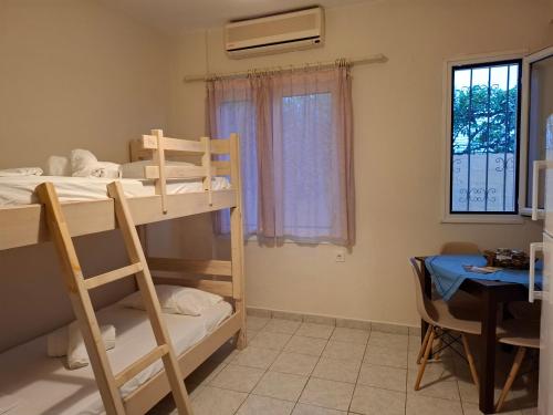 a room with two bunk beds and a table at Mamanis Studios in Loutra Edipsou