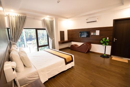 a bedroom with a large white bed and a tv at Kim Thanh Hotel, Vinh Phuc - Near Heron Lake Golf, Dam Vac in Vĩnh Phúc