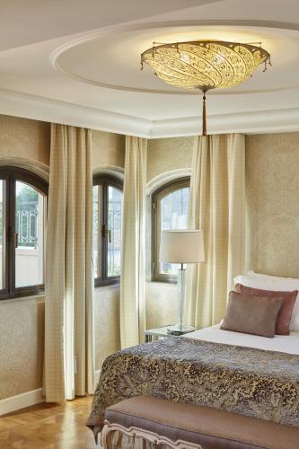 a bedroom with a large bed and a chandelier at Hotel Cipriani, A Belmond Hotel, Venice in Venice