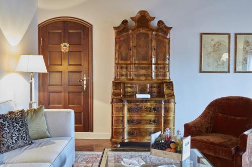 a living room with a couch and a large wooden cabinet at Hotel Cipriani, A Belmond Hotel, Venice in Venice
