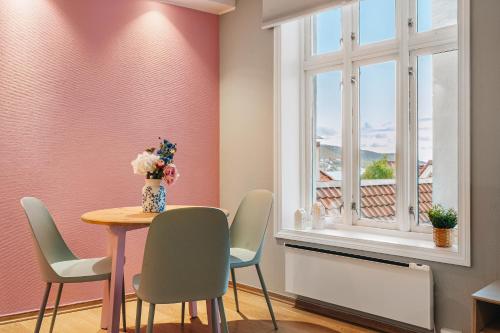 a dining room with a table and chairs and a window at Bergens Nr1 smau I Enkel innsjekk I Sjøutsikt in Bergen