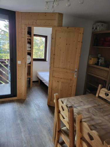 une salle à manger avec une table et une chambre avec une porte dans l'établissement Appartement T2 col de Merdassier au pied des pistes, à Manigod