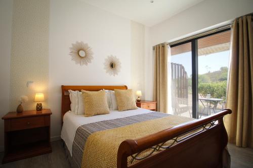 a bedroom with a bed and a large window at Villa Atitudo Nature in Portimão