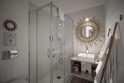 a bathroom with a shower and a sink and a mirror at Villa Atitudo Nature in Portimão