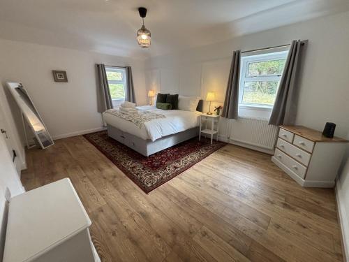 ein Schlafzimmer mit einem Bett, einer Kommode und einem Fenster in der Unterkunft Altchourunn Cottage in Acharra