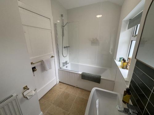 ein Badezimmer mit Badewanne, Dusche und Waschbecken in der Unterkunft Altchourunn Cottage in Acharra