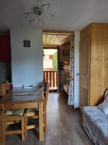 une salle à manger avec une table et une chambre avec un balcon dans l'établissement Appartement T2 col de Merdassier au pied des pistes, à Manigod