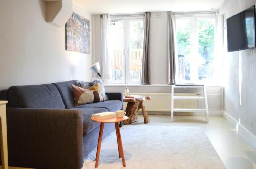a living room with a blue couch and a table at CANAL APARTMENT AMSTERDAM CENTRAL 4p in Amsterdam