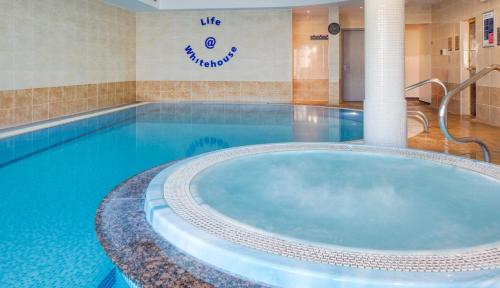 a large pool with a hot tub in a hotel room at The Worcester Whitehouse Hotel in Worcester