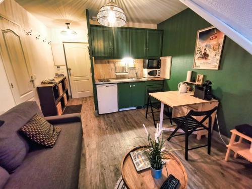 un salon avec un canapé et une table et une cuisine dans l'établissement Le Tranquille, Chaleureux T2, Centre-ville, à Le Mont-Dore