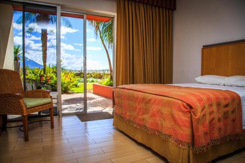 a hotel room with a bed and a view of a patio at Porta Hotel del Lago in Panajachel