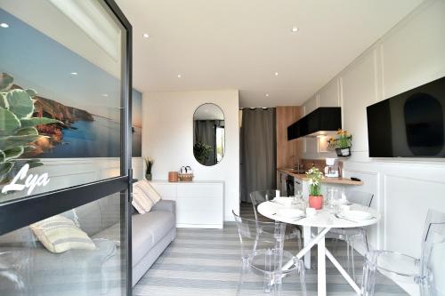 Il comprend un salon et une cuisine avec une table et des chaises. dans l'établissement Lya 04 - 5min à Pied de la Plage, à Fréhel